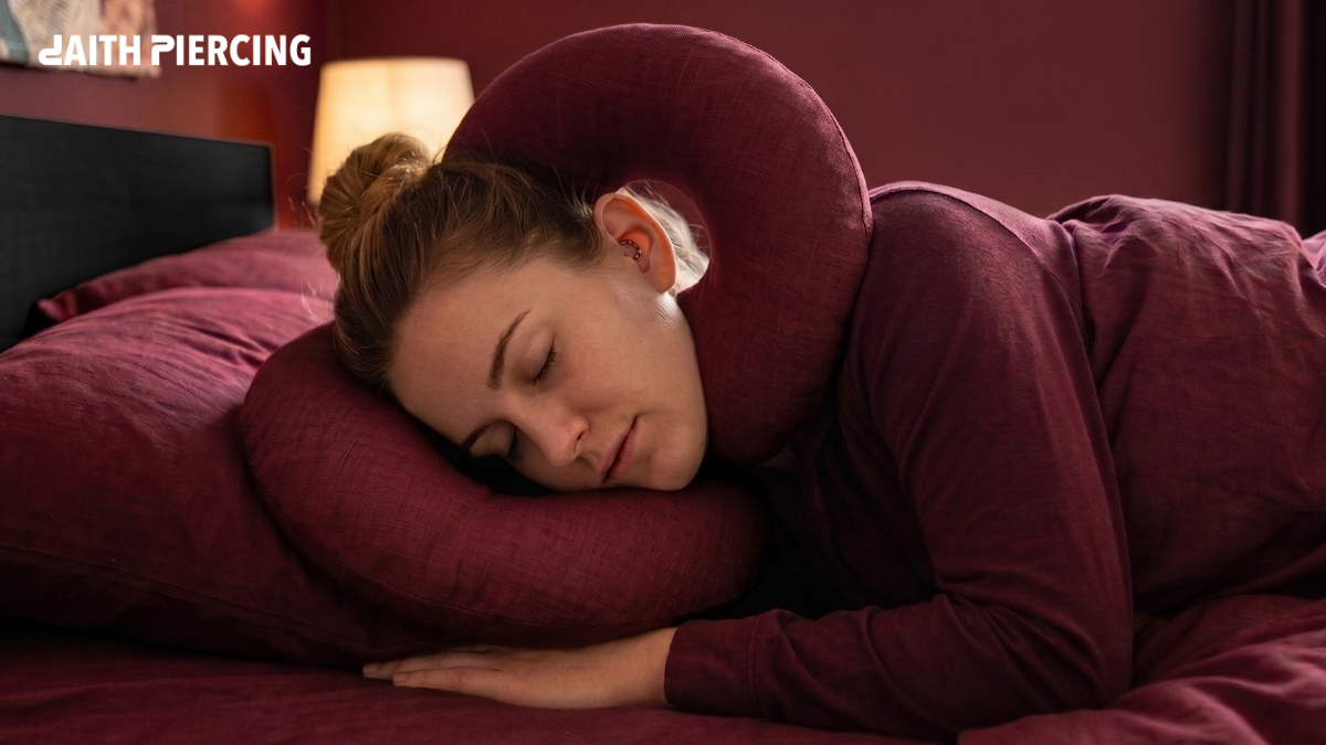 A woman sleeping on her side using a travel neck pillow to protect her new daith piercing from pressure.